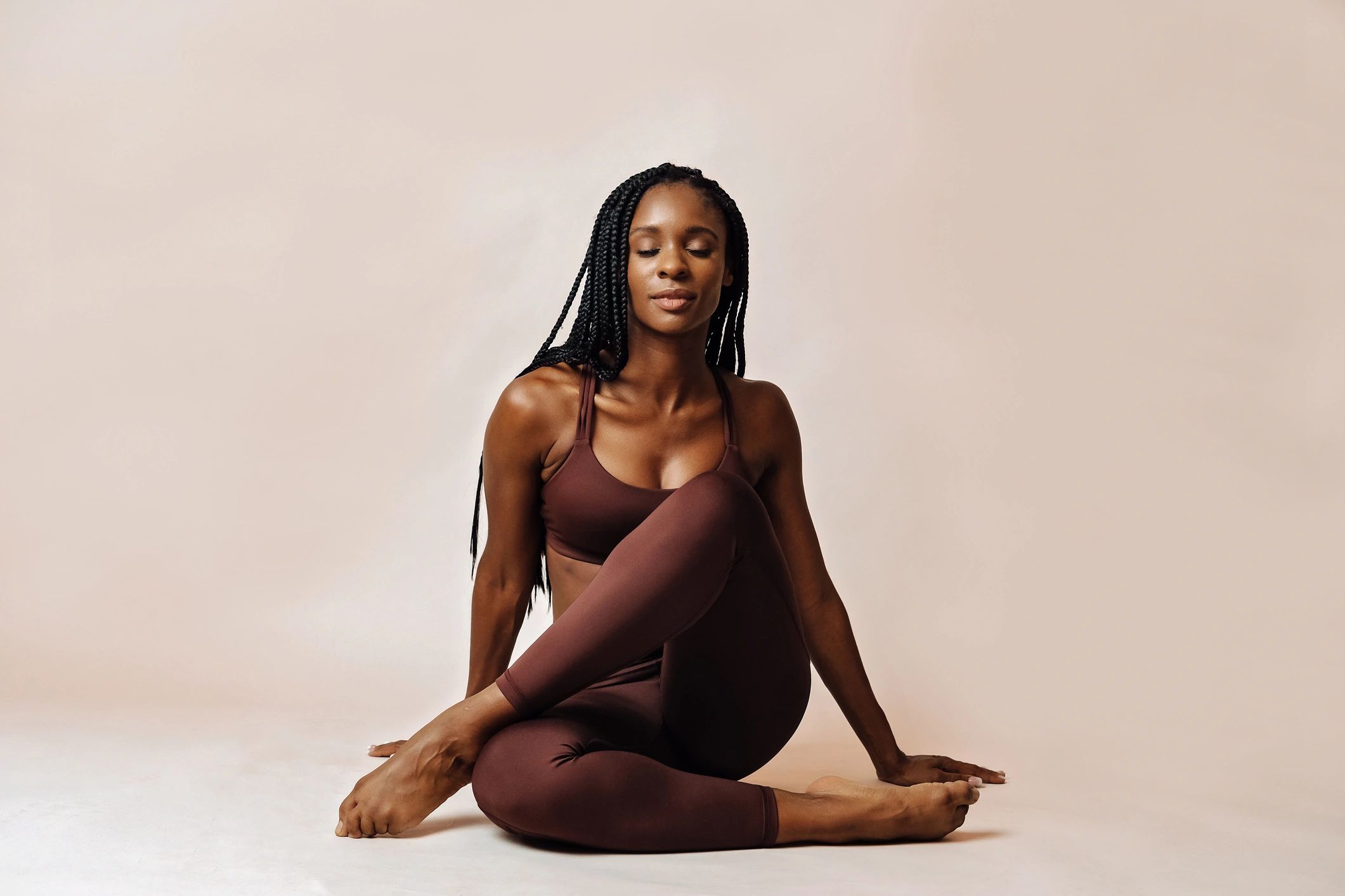 Black woman seated in lotus pose in a serene yoga studio