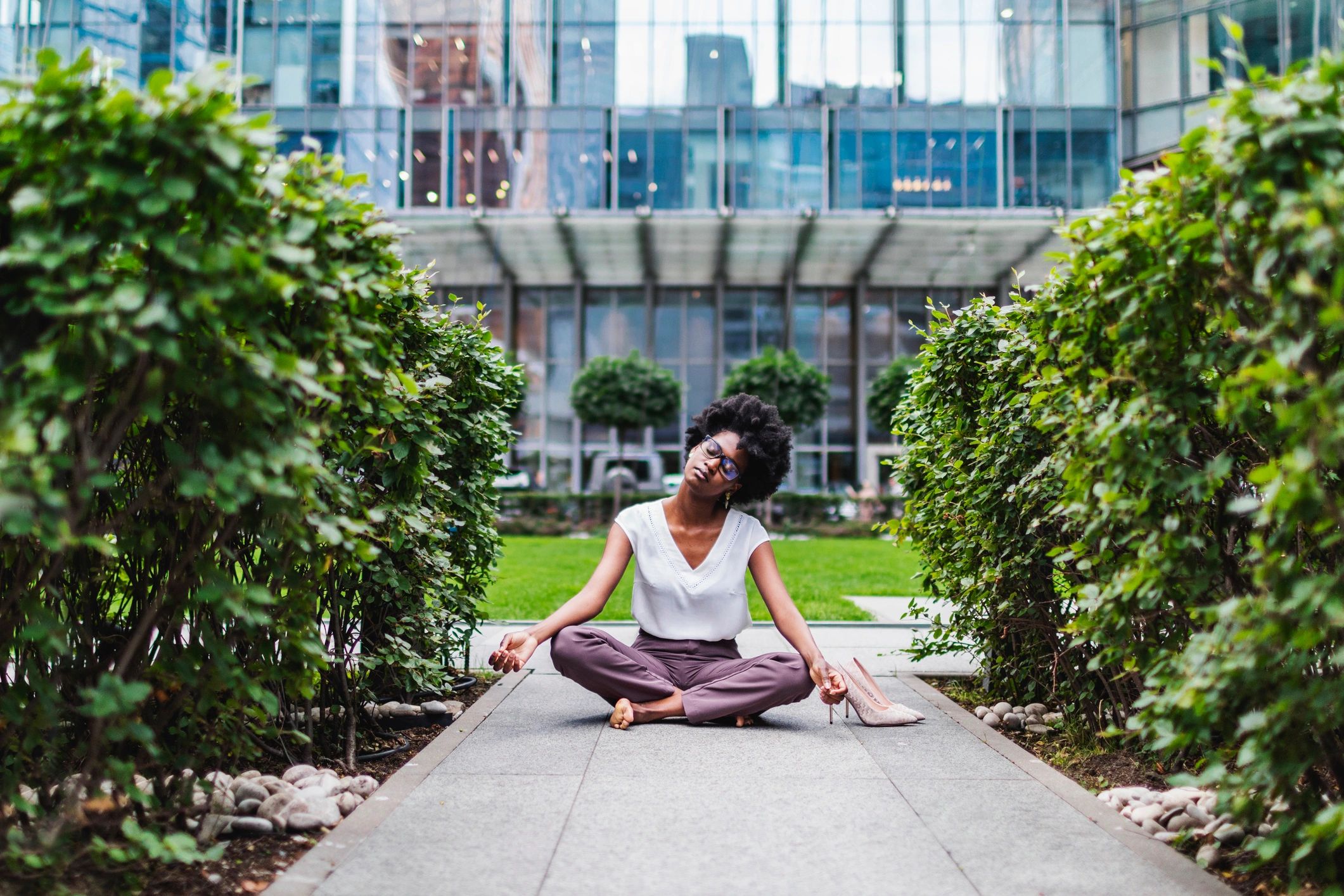 Black woman pausing outdoors with calm confidence in a soft city setting